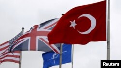 FILE - A Turkish flag, right, flies among others flags of NATO members at the Alliance headquarters in Brussels, Belgium, July 28, 2015. 