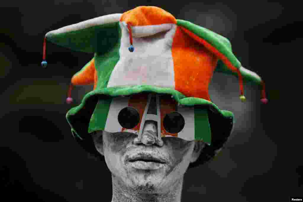 A man painted in the Ivory Coast flag&#39;s colors looks on during the commemoration of Ivory Coast&#39;s 55th Independence Day in Abidjan.