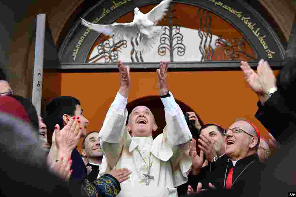 Pope Francis (C) releases a dove as a symbol of peace during a meeting with the Chaldean community at the Catholic Church of St. Simon Bar Sabbae in Tbilisi, Georgia.