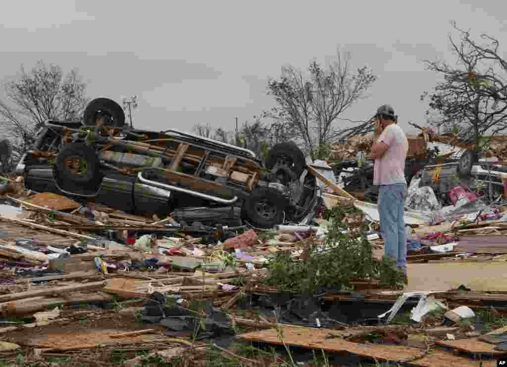 Seorang warga memeriksa kerusakan dekat karavan milik kawannya di Taman Karavan Steelman Estates, akibat tornado dekat Shawnee, Oklahoma (20/5). (AP/Sue Ogrocki)