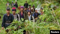 Montagnard hill tribesmen walk towards the main road after emerging from dense forest 70 km (43 miles) northeast of Ban Lung, located in Cambodia's northeastern province of Ratanakiri July 22, 2004. (Reuters)