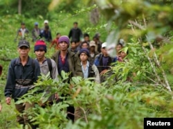 Montagnard hill tribesmen walk towards the main road after emerging from dense forest 70 km (43 miles) northeast of Ban Lung, located in Cambodia's northeastern province of Ratanakiri, July 22, 2004.