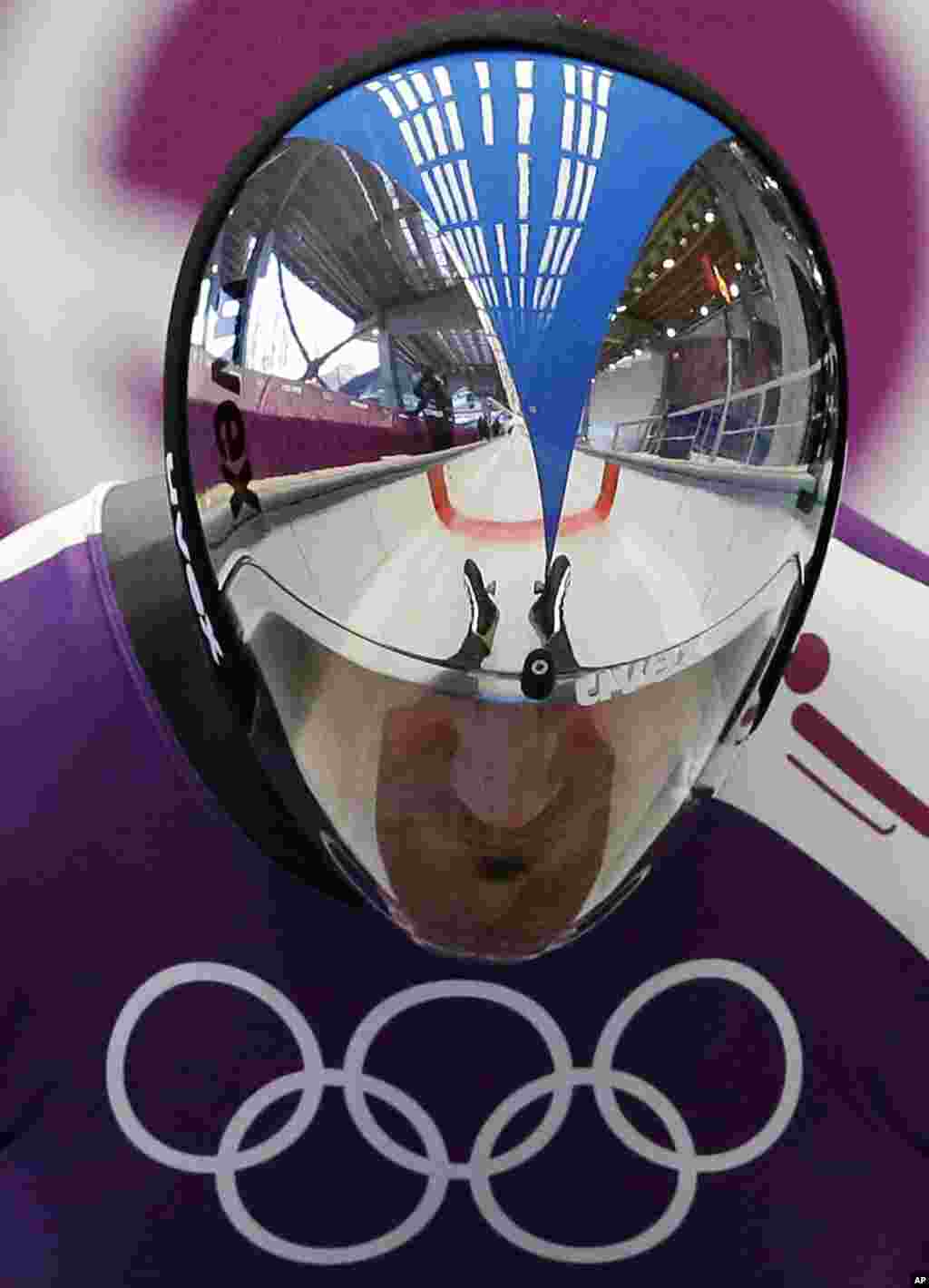 Armin Zoeggeler of Italy has his feet and the track reflected in his helmet as he starts a run during a training session for the men&#39;s singles luge at the 2014 Winter Olympics, in Krasnaya Polyana, Russia.