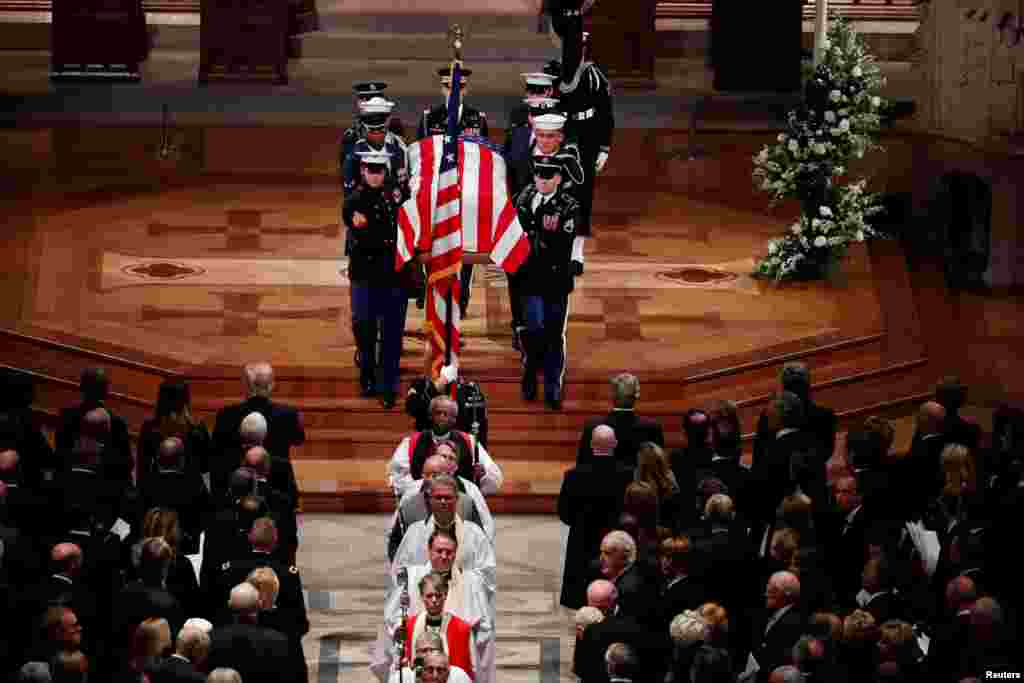 Members of the clergy and a military honor guard carrying the flag-draped casket depart at the conclusion of the state funeral for former President George H.W. Bush in the Washington National Cathedral, Dec. 5, 2018.