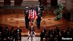 Members of the clergy and a military honor guard carrying the flag-draped casket depart at the conclusion of the state funeral for former President George H.W. Bush in the Washington National Cathedral in Washington, Dec. 5, 2018. 