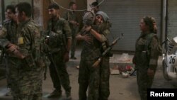 Deux combattantes des Forces démocratiques syriennes sont contentes de se retrouver dans la ville de Manbij, à Alep, Syrie, 10 août 2016.