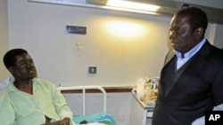 Zimbabwe's Prime Minister Morgan Tsvangirai visits Movement For Democratic Change youth leader Yaya Kassim, attacked while visiting MDC supporters, at a hospital in the capital Harare, August 5, 2011.