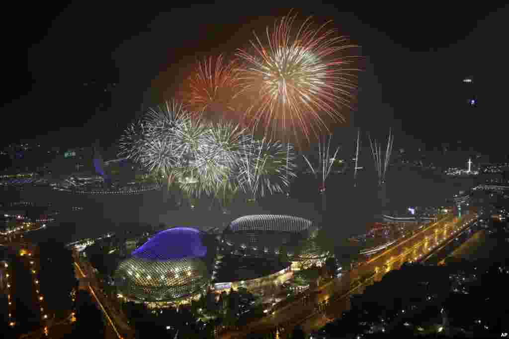 Kembang api meletup menerangi di atas distrik finansial Singapura tepat tengah malam pada perayaan Tahun Baru, 1 Januari 2018.&nbsp;