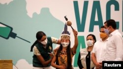 Vanderlecia Ortega dos Santos (Vanda) dari suku asli Witoto, saat disuntik vaksin COVID-19 produksi Sinovac di Manaus, Brazil, 18 Januari 2021. (REUTERS / Bruno Kelly)