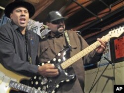 FILE - Blues musicians Ronnie Baker Brooks, left, and his brother, Wayne Baker Brooks, sons of blues legend Lonnie Brooks, perform in their basement in Dolton, Illinois, Feb. 12, 2008.