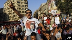 An Egyptian supporter of Muslim brotherhood candidate Mohammed Morsi wearing a shirt with Arabic that reads, "'Mohammed Morsi, president for Egypt" chants slogans in Tahrir Square, Cairo, Egypt, June 18, 2012.