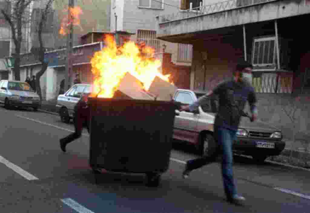 This photo, taken by an individual not employed by the Associated Press and obtained by the AP outside Iran shows Iranian protestors moving a garbage can which is set on fire, during an anti-government protest in Tehran, Iran, Monday, Feb. 14, 2011. Eyewi