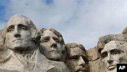 Izithombe zabomongameli abathi, u George Washington, Thomas Jefferson, Theodore Roosevelt lo Abraham Lincoln.
