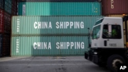资料照：在乔治亚州萨瓦纳港，一辆卡车驶过中国海运集团的集装箱。(2018年7月5日)