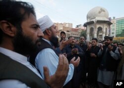 People pray for Pakistani police officer Tahir Dawar in Peshawar, Pakistan, Nov. 15, 2018.