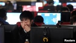 FILE - A man uses a computer at an internet cafe in Hefei, in China's Anhui province on March 16, 2012.