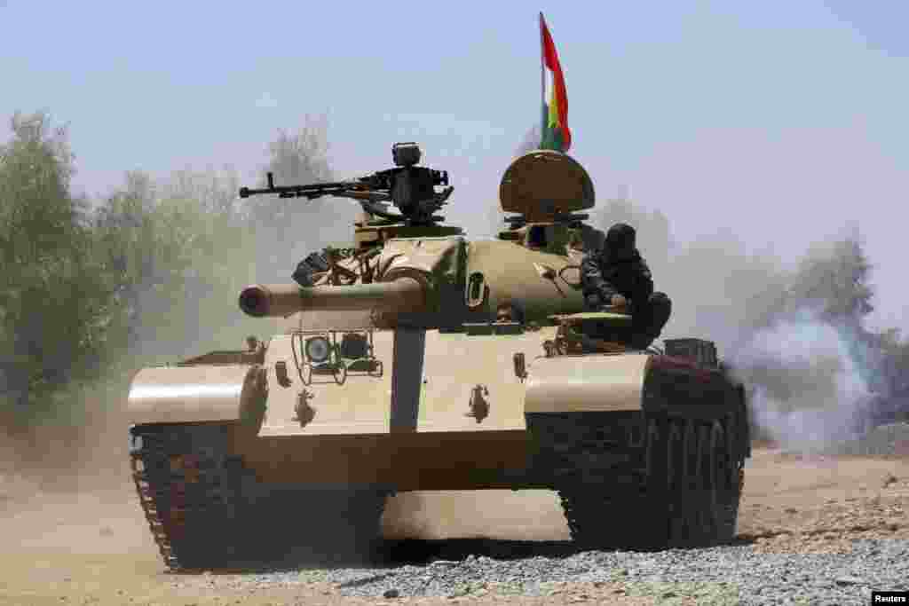 Kurdish peshmerga troops patrol in a tank during an operation against Islamic State militants in Makhmur, on the outskirts of the province of Nineveh, Aug. 7, 2014.