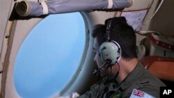 Awak pesawat angkatan udara Australia AP-3C Orion dalam pencarian pesawat Malaysia Airlines di atas Samudera Hindia (22/3). (AP/Rob Griffith)