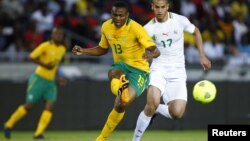 South Africa's Kagisho Dkgacoi (L) is challenged by Algeria's Adlane Guedioura during their international friendly soccer match in Soweto, January 12, 2013, in preparation for the 2013 Africa Cup of Nations. 