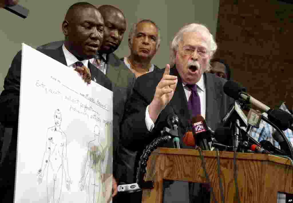 Dr. Michael Baden, right, speaks as the Brown family&#39;s attorney Benjamin Crump, left, holds a diagram produced during a second autopsy done on 18-year-old Michael Brown. in St. Louis County, Missouri, USA. The independent autopsy shows Brown was shot at least six times.