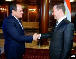 Russian Prime Minister Dmitry Medvedev, right, shakes hands with Egyptian President Abdel-Fattah el-Sissi during their meeting in Moscow, Oct. 16, 2018.