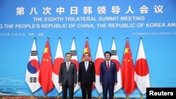 Los primeros ministros de China y Japón, Li Keqiang y Shinzo Abe, y el presidentesurcoreano, Moon Jae In, antes de comenzar una cumbre tripartita en China el 24 de diciembre de 2019.