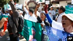 Protesters raise clenched fists with banners printed with detained activist Vorn Pao in front of the Appeals Court during a rally in Phnom Penh, file photo. 