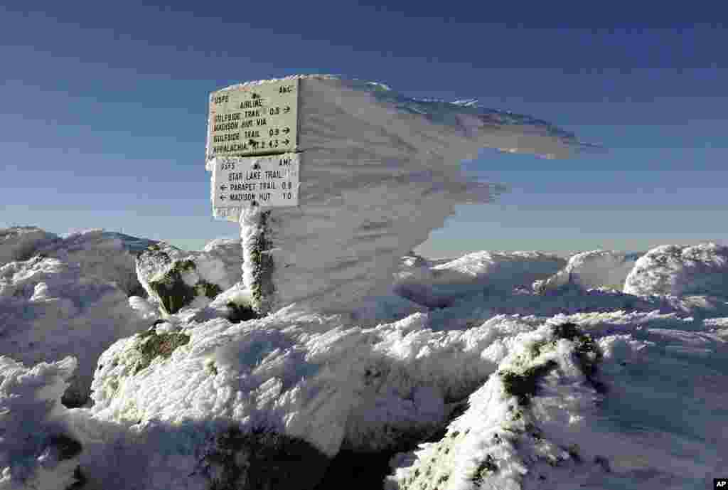 Rime ice extends several feet horizontally from a sign marking the summit of 5,774-foot Mount Adams, the second highest mountain in New England, in northern New Hampshire, USA, Nov. 17, 2015.