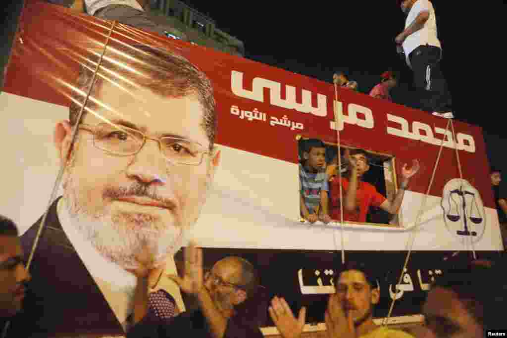 Tahrir maydonida prezident Muhammad Mursiyning tasvirini ko&#39;targan odamlar, Qohira, Misr, 10-iyul, 2012-yil.