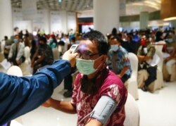 Seorang pria menjalani pemeriksaan kesehatan sebelum dia diinokulasi dengan Sinovac China selama program vaksinasi massal di sebuah pusat perbelanjaan di Jakarta, 1 April 2021. (Foto: REUTERS/Ajeng Dinar Ulfiana)