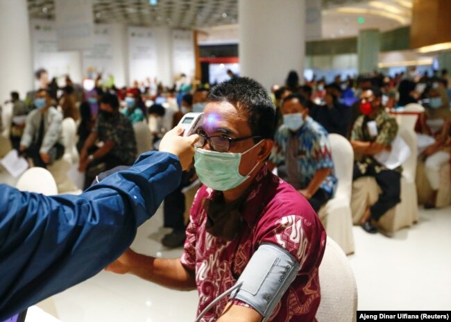 Seorang pria menjalani pemeriksaan kesehatan sebelum dia diinokulasi dengan Sinovac China selama program vaksinasi massal di sebuah pusat perbelanjaan di Jakarta, 1 April 2021. (Foto: REUTERS/Ajeng Dinar Ulfiana)