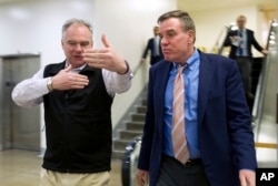 Sen. Tim Kaine, D-Va., speaks with Sen. Mark Warner, D-Va., as they walk to their offices Jan. 20, 2018, on Capitol Hill in Washington. Republicans and Democrats showed no signs of ending their standoff over immigration and spending Saturday as Americans awoke to the first day of a government shutdown and Congress staged a weekend session to show voters it was trying to resolve the stalemate.