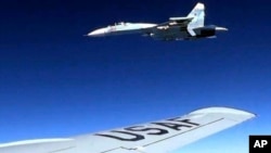 FILE - In this image released by the U.S. Air Force, a U.S. RC-135U flying in international airspace over the Baltic Sea, is intercepted by a Russian SU-27 Flanker, June 19, 2017. A Russian jet made an "unsafe" intercept of an American reconnaissance plane flying in international airspace over the Black Sea, Nov. 5, 2018, Pentagon officials said.