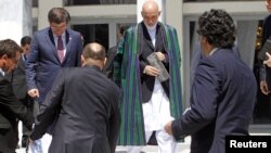 Afghan President Hamid Karzai (C) arrives for a group photo with the foreign attendees of the Asia Ministerial Conference in Kabul, June 14, 2012. 