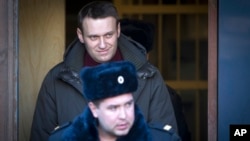 Russian opposition activist Alexei Navalny, surrounded by police officers, leaves a court after being sentenced to seven days in prison for participating in an anti-government protest in Moscow, Feb. 25, 2014.