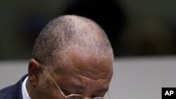 Former Liberian President Charles Taylor takes notes as he waits for the start of a hearing to deliver verdict in the court room of the Special Court for Sierra Leone in Leidschendam, near The Hague, Netherlands, April 26, 2012.