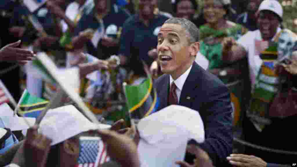 Rais Obama akitoa mkono kwa wanawake kwenye msitari wa kumkaribisha alipowasili Dar es Salaam.