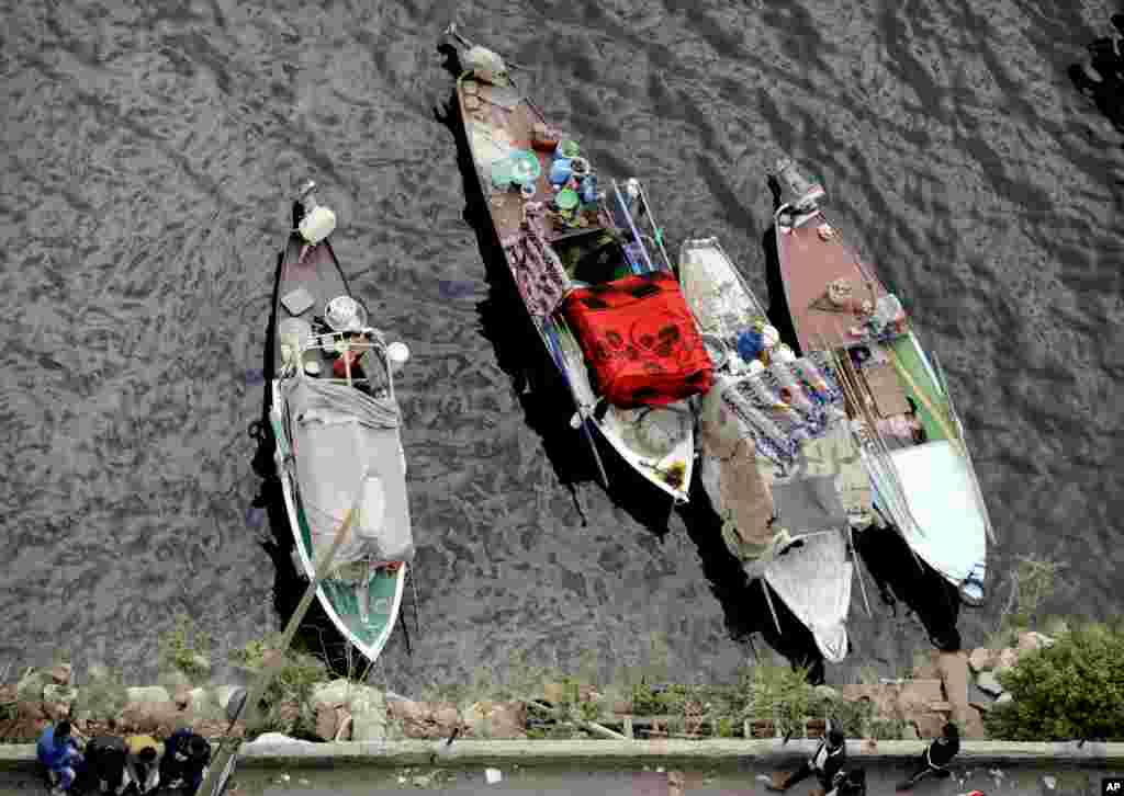 Egyptian fishermen cover their boats with blankets due to cold weather on the Nile River, in Cairo.