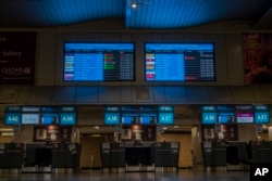 FILE - Some foreign airlines check-in counters are seen closed at Johannesburg's OR Tambo's airport, South Africa, Nov. 29, 2021.