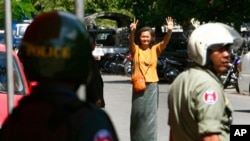 A Cambodian lawmaker from the main opposition party of Cambodia National Rescue Party (CNRP) Mu Sochua, center, gestures to make the number seven, the party's ballot number, before being detained by authorities at Freedom Park, in Phnom Penh, file photo. 