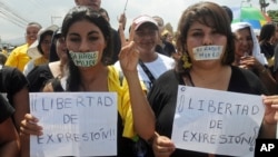 ARCHIVO - Esta imagen muestra a manifestantes con carteles de apoyo a la libertad de expresión y en protesta contra lo violencia hacia los periodistas y medios de comunicación en Tegucigalpa, Honduras. El país ha pasado por varios períodos de violencia contra la prensa.