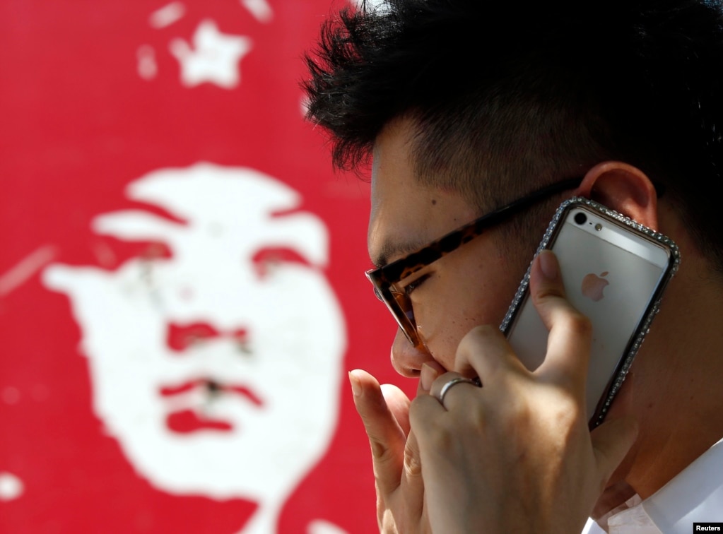 有中国人用苹果手机打电话，旁边是雷锋画像（2013年）。中国青年热衷于iPhone，而不是雷锋。而中国当局谨防iPhone之类的上网工具带来&ldquo;西风&rdquo;&mdash;&mdash;来自西方和海外的对当局不利的信息和影响，也希望让其1960年代的洗脑工具雷锋成为人们学习的榜样。