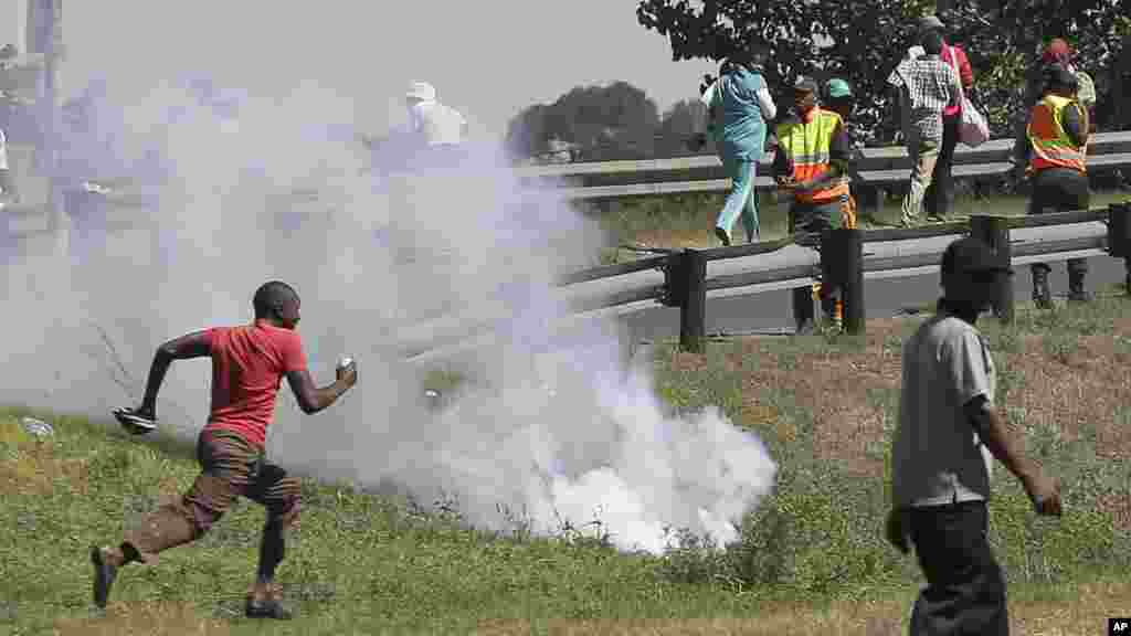 Wakazi wa kitongoji cha mashariki ya Johanesburg wakimbia wakati polisi wanafyetua mabomu ya kutoa machozi kuwatawanya waandamanaji wanaowapinga wageni.