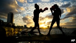 Boxers Idamelys Moreno, left, and Legnis Cala, train during a photo session on Havana's sea wall, in Cuba, Jan. 30, 2017. 