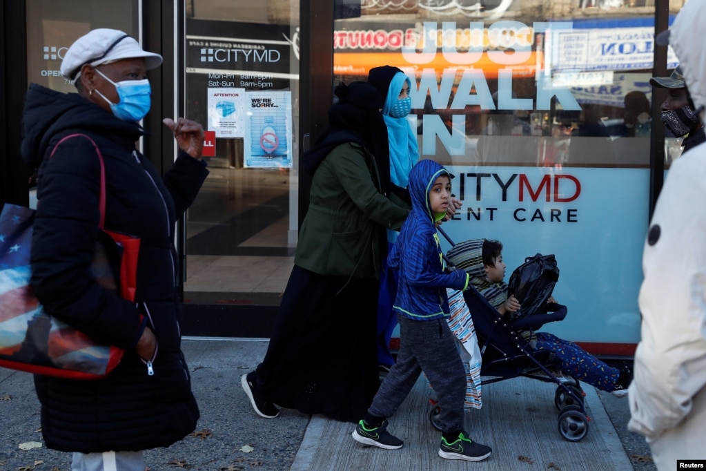 People wear protective face masks while waiting in line at a CityMD Urgent Care, as the global outbreak of the coronavirus disease (COVID-19) continues, in the Brooklyn borough of New York, U.S., November 16, 2020. REUTERS/Shannon Stapleton