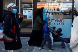 Para pengunjung mengenakan masker wajah saat mengantre di CityMD Urgent Care di tengah pandemi Covid-19 di Brooklyn, New York, Senin, 16 November 2020. (Foto: Reuters)