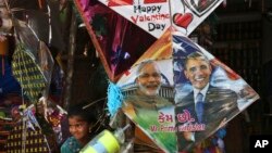 在印度海得拉巴的風箏節前夕，一名印度女孩站在一家店鋪出售的畫有印度總理莫迪和美國總統奧巴馬頭像的風箏邊。（2015年1月12日）