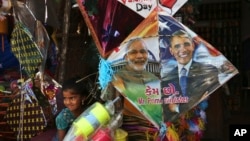 FILE - An Indian girl stands near a kite with portraits of India's Prime Minister Narendra Modi and U.S. President Barack Obama, for sale at a shop ahead of the Hindu festival Makar Sakranti, also known as kite festival, in Hyderabad, India, Jan. 12, 2015.
