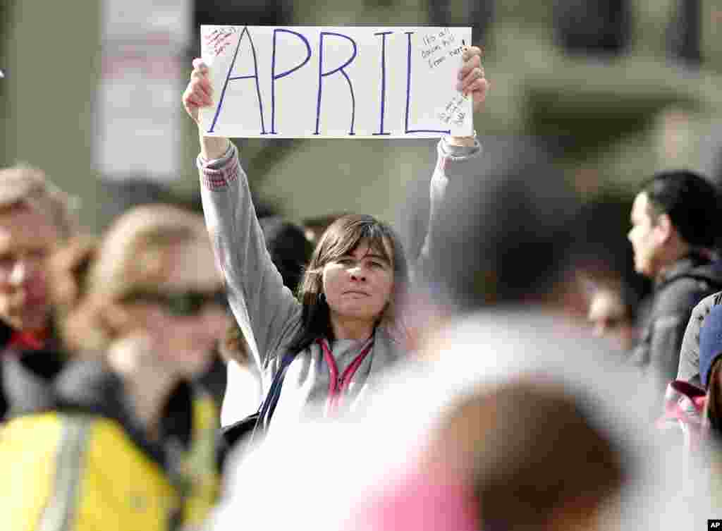 Justine Franco of Montpelier, Vermont, holds up a sign near Copley Square looking for her missing friend, April, who was running in her first Boston Marathon, April 15, 2013. 