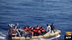 This handout picture released by the Italian Navy on June 6, 2014 shows migrants on boats being arrested and rescued by the Italian army off the coast of Sicily. The Italian navy on June 6 said it had rescued around 2,500 asylum-seekers in the Mediterranean.